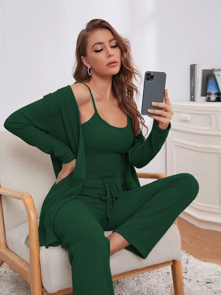 a woman sitting on a green chair talking on a cell phone 