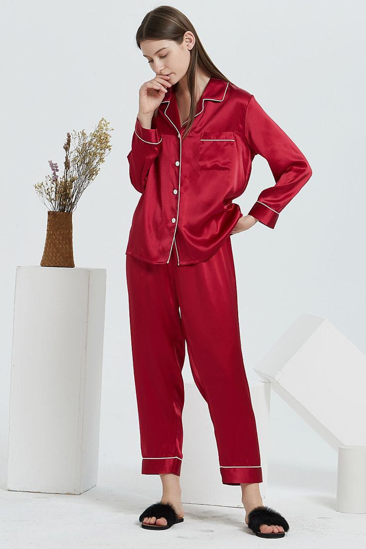 a woman in a red coat is standing in the snow 