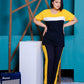 a woman standing in front of a wall holding a surfboard 