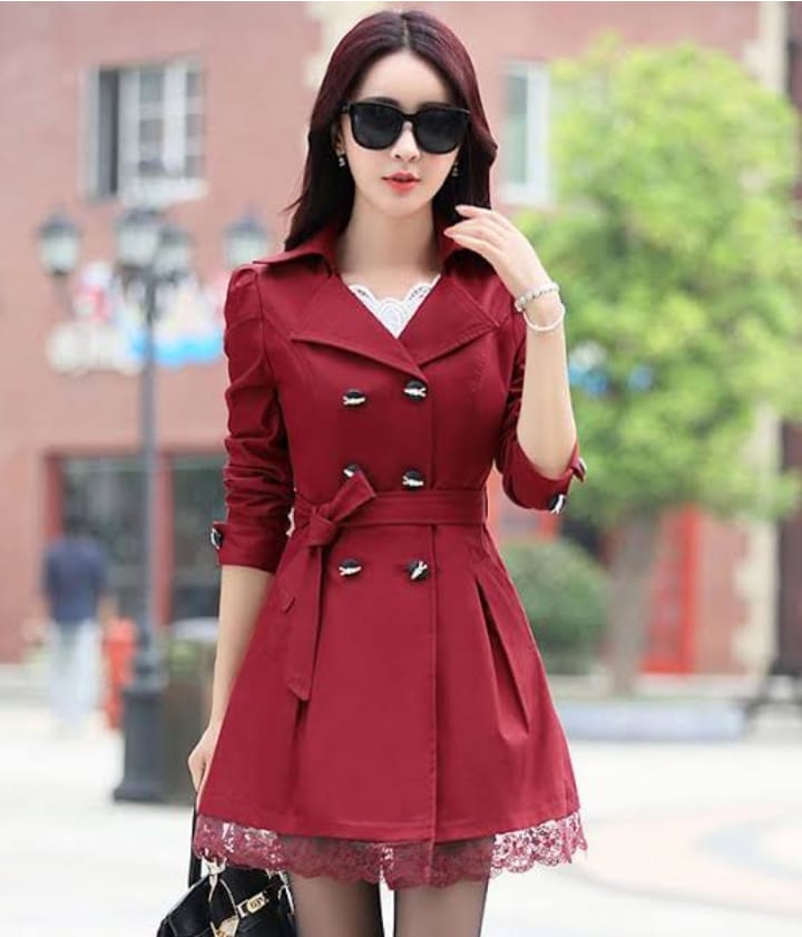 a woman in a red dress standing on a sidewalk 