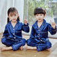 a couple of kids sitting on top of a wooden floor 