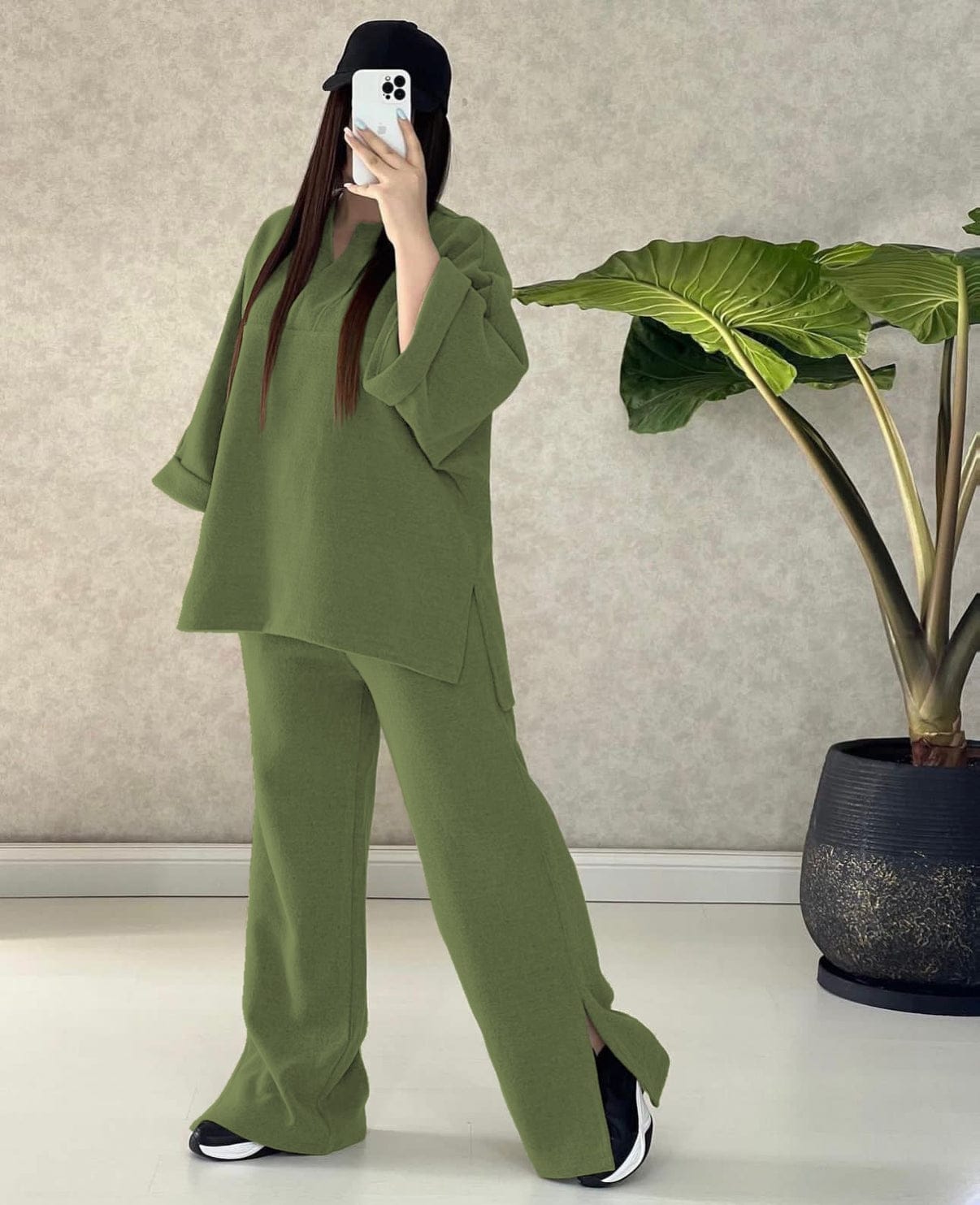 a woman in a green dress talking on a cell phone 