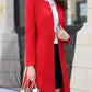 a woman in a red dress standing on a sidewalk 