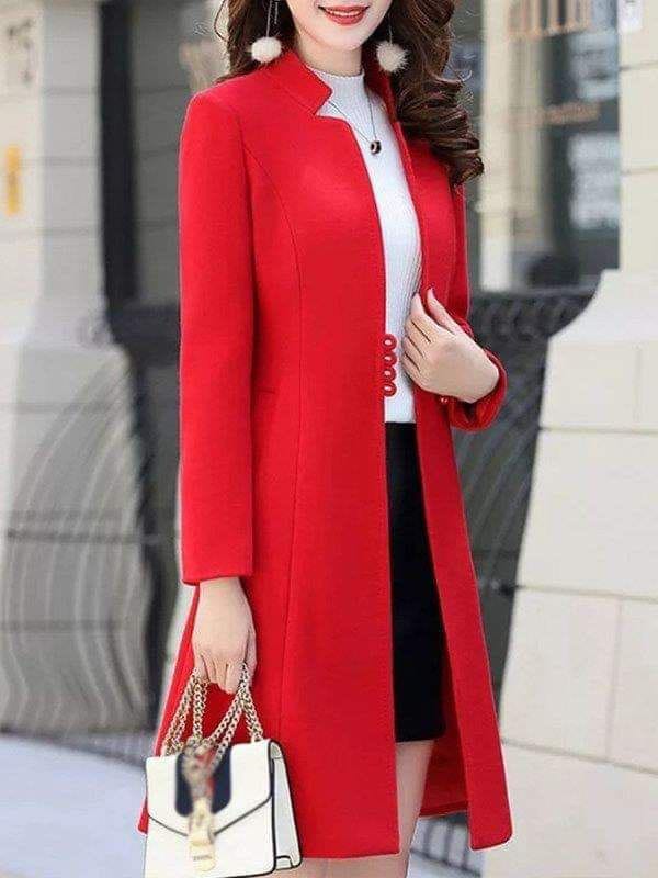 a woman in a red dress standing on a sidewalk 