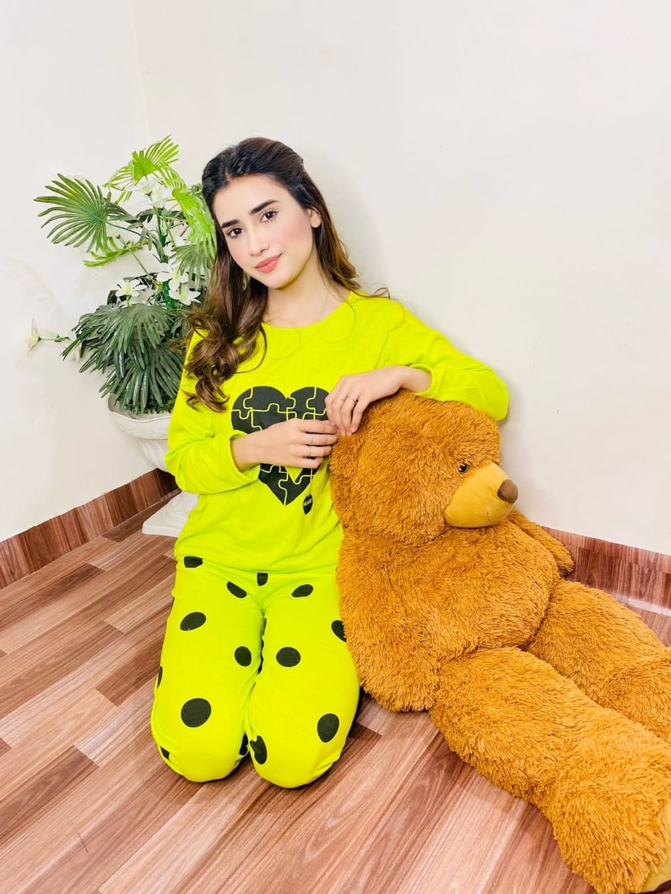 a woman in a yellow sweater holding a teddy bear 